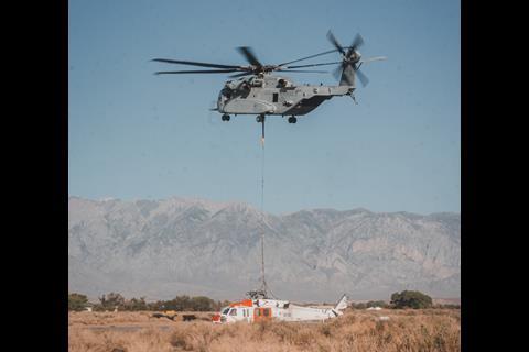 CH-53K King Stallion lowers a Navy MH-60S Knighthawk Helicopter to the ground after recovering it c USMC